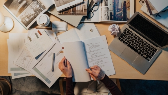 Screenwriter at desk with script and laptop on table