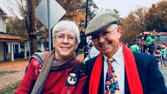 man and woman riding in car with christmas clothes on