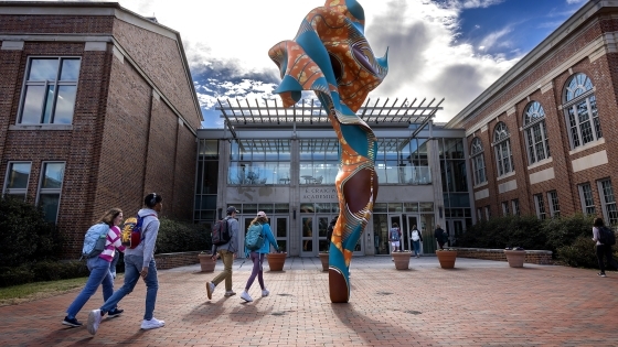 Spring day in front of the Wall Building with Shonibare sculpture and students in the foreground