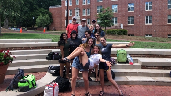 a group of students standing on brick stairs outside on a college campus