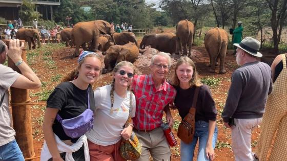 a group of people standing in front of an elephant enclosure