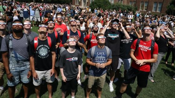 Davidson community on the front lawn observing w safety glasses the 2017 Davidson Eclipse