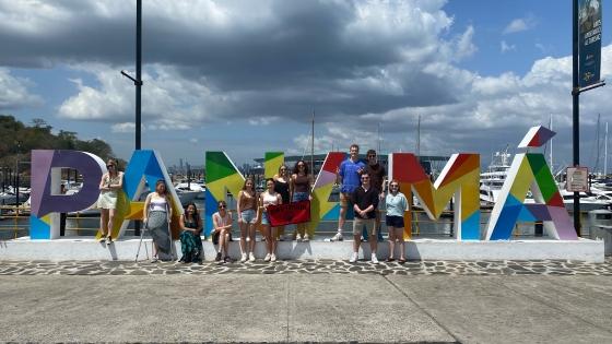 a group of students stand in front of a sign that reads "Panama"