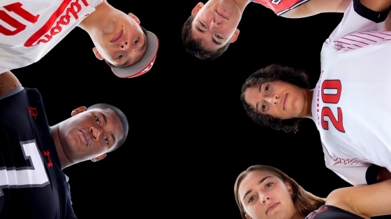 Student athletes huddled around camera
