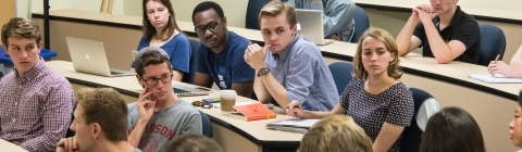Large class of students looks at a classmate as she speaks