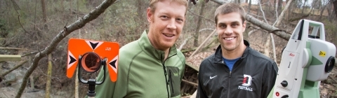 Prof. Brad Johnson and student stand in field with research equipment