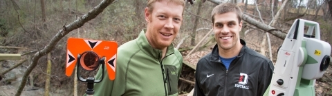 Prof. Brad Johnson and student stand in field with research equipment  