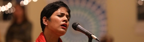 Singer at Diwali sings into microphone with eyes closed