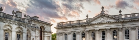 University of Cambridge marble buildings in front of a pink and blue cloudy sky