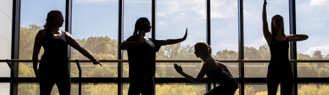 Four dance students pose near a window on a sunny day at one of Davidson's dance studios