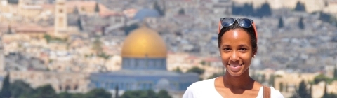 Student stands in front of Amman skyline in Jordan.