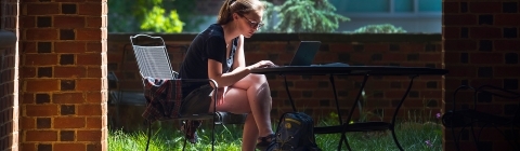 Student sits in the outdoor classroom studying