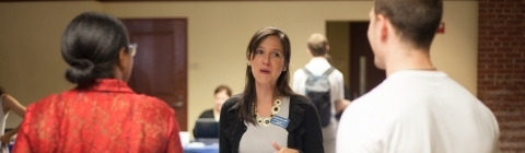 Recruiter talks to students at a booth at job fair