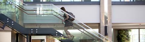 Student goes up Wall Center glass staircase