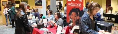 Student stops at booth at a fair in the Union to talk to a recruiter