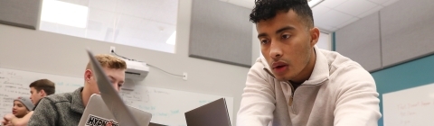 Student typing on laptop