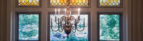 Picture of chandelier and stained glass window inside the Guest House
