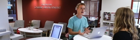 Student sits with career counselor to discuss job opportunities