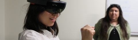 Student wears VR headset and uses VR equipment