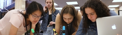 Kids from summer program work together on a poster