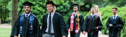 Students walking in regalia to commencement