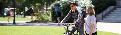 Students talk with one on bike