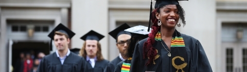 Procession of students in regalia walking into commencement