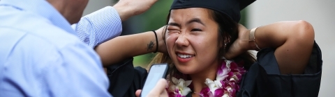 Family member adjusts the cap of graduating student