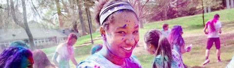 Student is covered in colorful powders during Holi celebrations