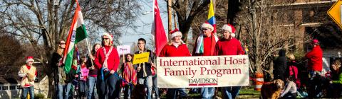 Host families march in Christmas parade with sign