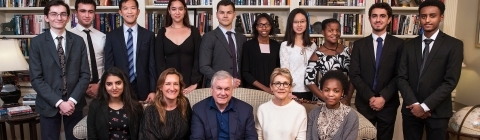 Alvarez family poses with students in front of bookshelves