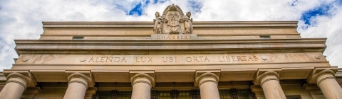 Top of Chambers building next to a cloudy sky