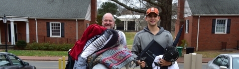 Student and family member carry arms full of items into dorm