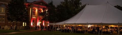 Ne Ultra Event with people under outdoor dining tent and wall lit up in red