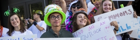Group of Students Hold Up Funny Signs at Orientation