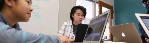 Three students busy working on laptops