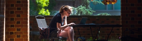 Student on Laptop Outside Library