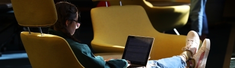 Student Studying in Library on Laptop