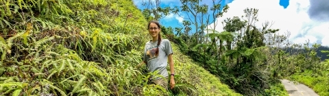 Lydia Soifer stands on a hill covered in vegetation