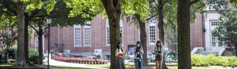 Students Conducting Binocular Experiment on Campus Surrounded by Trees