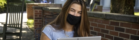 Student on Laptop and Mask Studying Outside