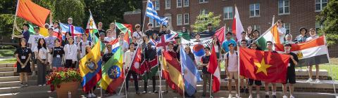 group of international students hold country flags on Alvarez Union steps