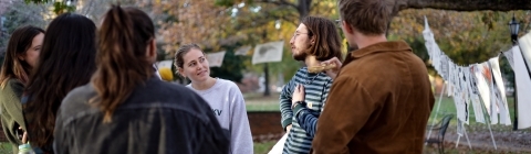 Students in a group outside, surrounded by papers on clotheslines