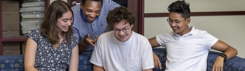 Group of students around laptop