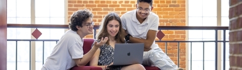 Group of students around laptop