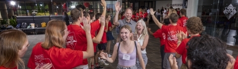 student and family walking through welcome tunnel during Orientation