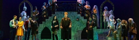 students onstage wearing Addams Family costumes