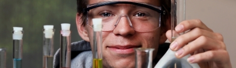 Student holding up beakers of various colors