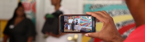 Man holding phone taking picture of people at BSC