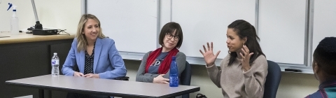 three women speaking at a table